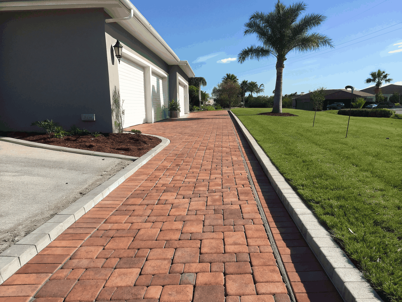Custom brick paver and stamped concrete driveway installation