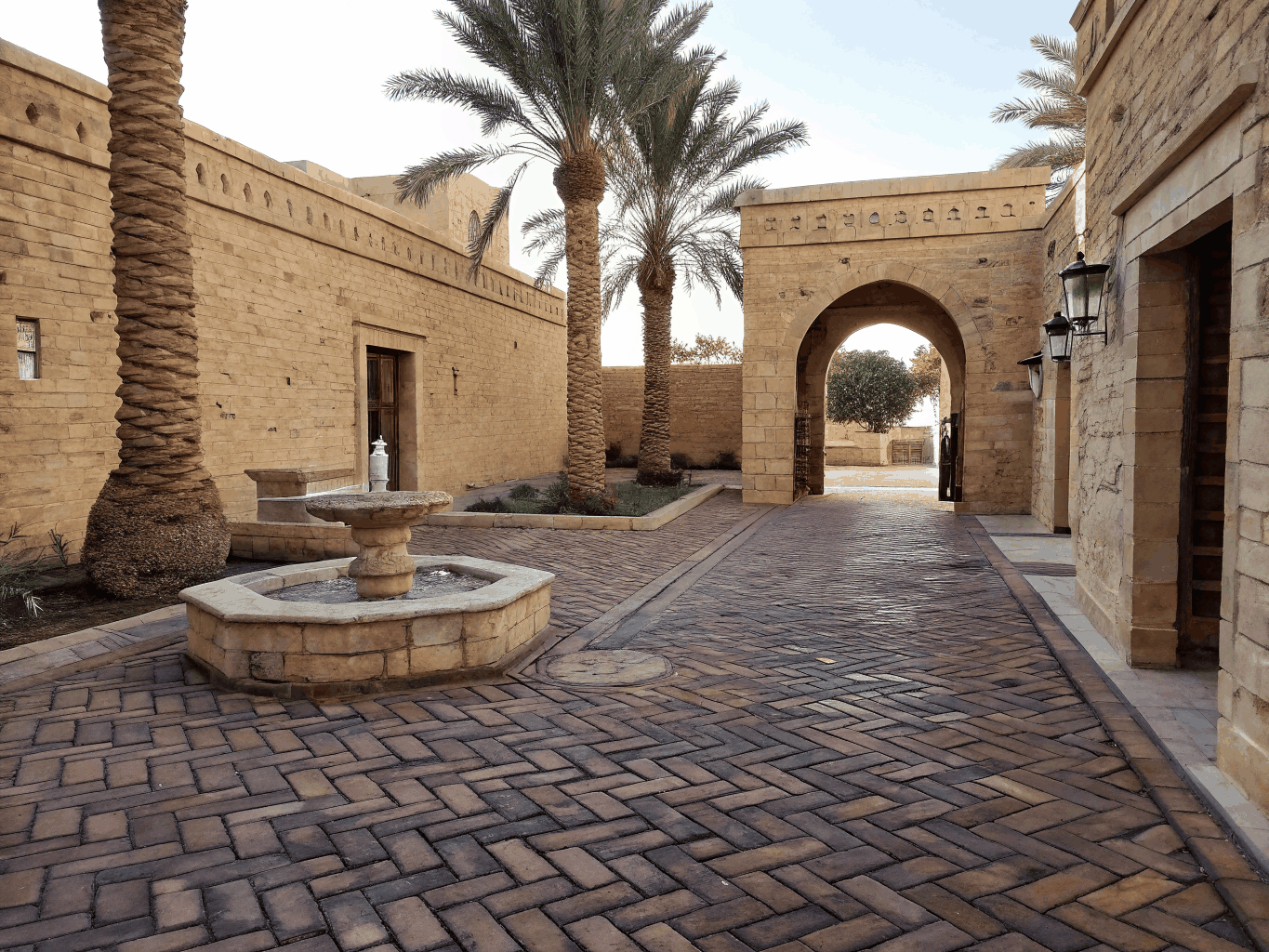 Warm brick paver courtyard and terrace surrounded by lush residential landscaping